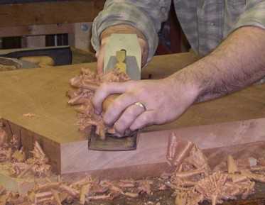[IMAGE: JP is hand planing a large Mahogany board]